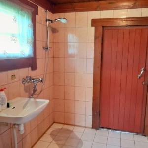 ein Badezimmer mit Waschbecken und roter Tür in der Unterkunft Öökulli öömaja in Tartu + 5 Fotos