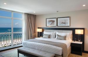 a bedroom with a large bed and a large window at Miramar By Windsor Copacabana in Rio de Janeiro