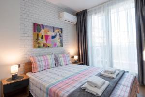 a bedroom with a bed with towels on it at Best Guest 2 Apartments in Plovdiv