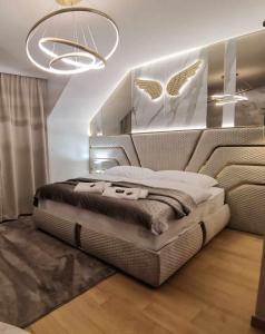 una camera da letto con un letto grande con una grande testiera di Stay PRESTIGE Apartment - Luxury Trnava, FREE INDOOR PARKING a Trnava