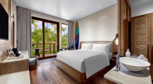 a bedroom with a bed and a sink and a tub at Holiday Inn Resort Bali Canggu by IHG in Canggu