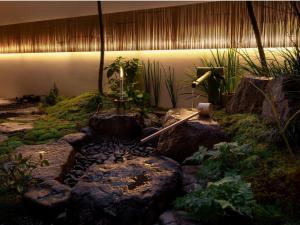 un jardín con un estanque con rocas y plantas en THE JUNEI HOTEL KYOTO - Vacation STAY 14489v, en Kioto 32 fotos más