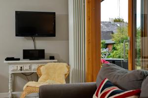 sala de estar con sofá, TV y chimenea en Ankerlicht - Bungalow L, en Westerland 1 foto más