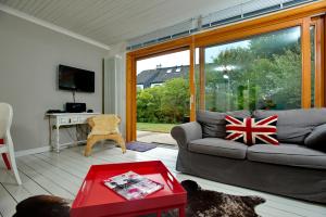 Una sala de estar con un sofá y una ventana grande. en Ankerlicht - Bungalow L, en Westerland