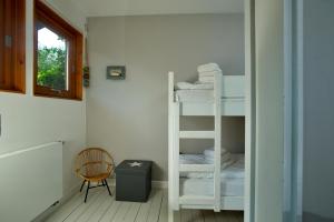 una habitación con dos literas y una silla en Ankerlicht - Bungalow L, en Westerland