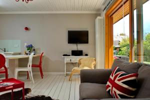 Una sala de estar con un sofá y una mesa con televisión. en Ankerlicht - Bungalow L, en Westerland