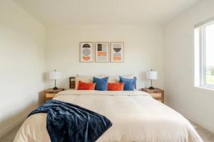 - une chambre dotée d'un grand lit avec des oreillers bleus et oranges dans l'établissement Stylish 4br Fast Wifi Sleeps 10, à Barrie