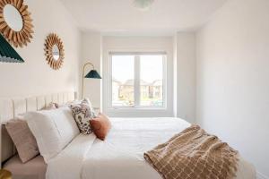 une chambre blanche avec un lit et une fenêtre dans l'établissement Stylish 4br Fast Wifi Sleeps 10, à Barrie 27 autres photos