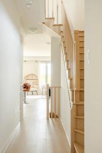 una escalera en una casa con paredes blancas y suelo de madera en Stylish 4br Fast Wifi Sleeps 10, en Barrie