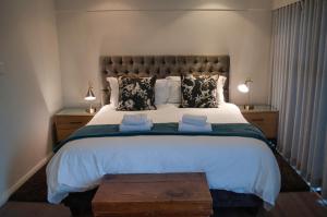 Un dormitorio con una cama grande con dos almohadas. en Stellenbosch Upper Class Penthouse, en Stellenbosch