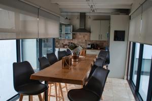 Una cocina y un comedor con mesa y sillas de madera. en Stellenbosch Upper Class Penthouse, en Stellenbosch