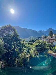 ein Wasserkörper mit Bäumen und Bergen im Hintergrund in der Unterkunft Mountain View Villa in São Vicente