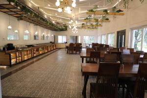 a dining room with tables and chairs and windows at Aacorn Hideaway Resort & Spa in Rāmnagar