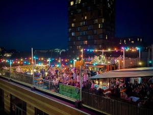 a crowd of people sitting at a party at night at Urban Camper Hostel & Bar in Copenhagen