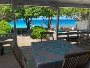 a table on a porch with a view of the beach at Faré Pépénai in Avatoru