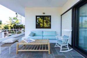 a blue couch and two chairs on a balcony at Danae's Art in Athens