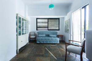 a living room with a blue couch and some windows at Danae's Art in Athens