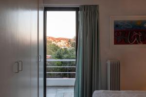 a bedroom with a sliding glass door to a balcony at Danae's Art in Athens
