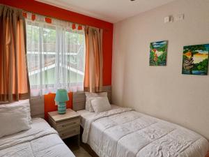 a bedroom with two beds and a window at The Nest 2 Bedroom1 Bath Condo Rooftop Patio in Coco +36 photos