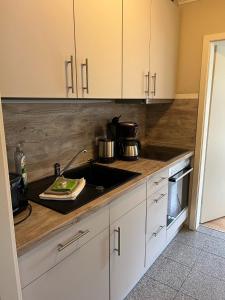 a kitchen with a sink and a stove top oven at Haus Seeschwalbe - Wohnung 07 in Spiekeroog +12 photos