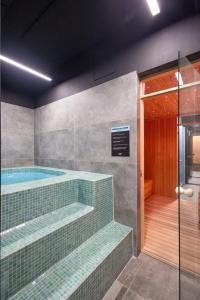 a bathroom with a swimming pool and a walk in shower at Mercure Prishtina City in Pristina