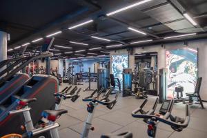 a gym with lots of cardio equipment in it at Mercure Prishtina City in Pristina
