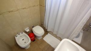 a bathroom with a white toilet and a sink at Hornera Italia - Céntrico, práctico y luminoso in Rosario