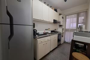 une cuisine avec des armoires blanches et un réfrigérateur dans l'établissement Hornera Mai - El lugar perfecto, à Rosario