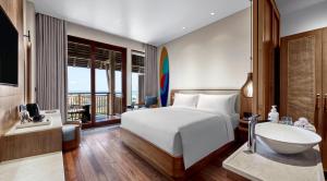 a bedroom with a bed and a bathroom with a sink at Holiday Inn Resort Bali Canggu by IHG in Canggu