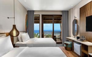 a hotel room with two beds and a view of the ocean at Holiday Inn Resort Bali Canggu by IHG in Canggu
