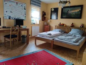 a bedroom with a bed and a desk with a computer at Gemütliches Fachwerkhaus Hessen Thüringen in Herleshausen +17 photos