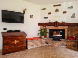 ein Wohnzimmer mit Kamin und Flachbildfernseher in der Unterkunft La Cà Granda, quiet house with mountain views in Gandellino