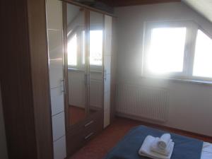 a bedroom with a closet with towels on a bed at Ferienhaus Bolliger Apartment 3 in Kalkhorst