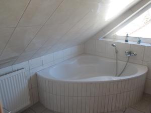 a bath tub in a bathroom with a window at Ferienhaus Bolliger Apartment 3 in Kalkhorst +4 photos