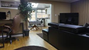 a living room with a black leather couch and a table at Berrow Breeze in Burnham on Sea