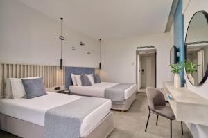 a hotel room with two beds and a mirror at Blue Sea Beach Resort in Faliraki
