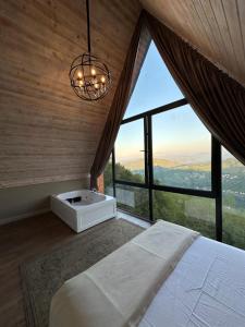 a bedroom with a bed and a large window at Akcatepe Dag Evleri in Akcaabat