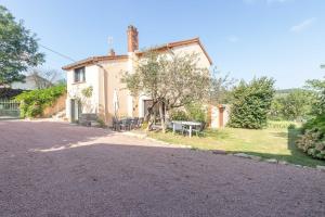 JalognyにあるCabana & Maison sur les hauteurs - Proche Clunyのテーブルとベンチが前にある家