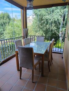 a dining room with a table and chairs on a balcony at Casa Navarenas in San Martín del Pimpollar