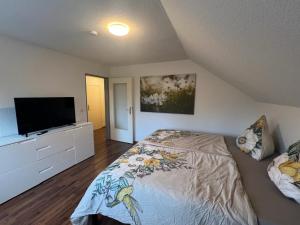 a bedroom with a bed and a flat screen tv at Workers Apartment with Balcony in Bielefeld in Bielefeld