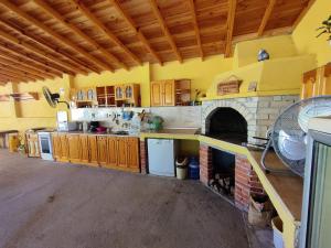 a large kitchen with a stone fireplace in a room at Вила Сириус in Sinemorets