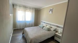 a bedroom with a bed with pillows and a window at Apartamento A Costa Da Morte in Santa Comba