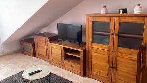 a living room with a tv and a wooden entertainment center at Apartamento A Costa Da Morte in Santa Comba