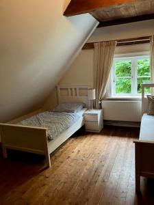a bedroom with a bed and a window at Haseldorfer Landliebe in Haseldorf