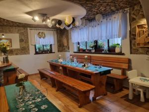 a dining room with a large wooden table and benches at Zajazd Józef in Witów +104 photos