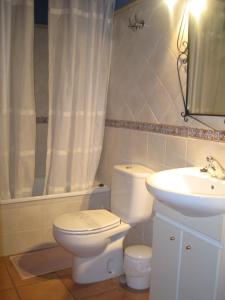 a bathroom with a white toilet and a sink at Casa El Cantón in La Cuba
