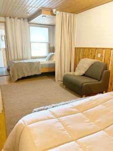 Un dormitorio con una cama y un sofá y una ventana. en Vanhan Karhun Huoneistot, en Ruka