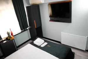 a bedroom with a bed and a flat screen tv at Grand Onur Hotel in Istanbul