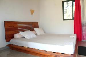 a bedroom with a large bed with a wooden headboard at Résidence Oriole in Hell-Ville +10 photos