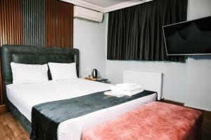 a hotel room with a bed and a flat screen tv at Grand Onur Hotel in Istanbul +10 photos